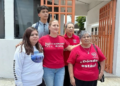 Nuevo-leon-niega-aumento-de-apoyos-a-hijos-desaparecidos - La Sultana Informa Group of Five People Posing Outside a Building with Orange Gates; Two Women Wear Red Shirts, One in a White Long-sleeve Shirt with 'buscadores' on the Sleeve, and a Teen Behind Them. - La Sultana Informa